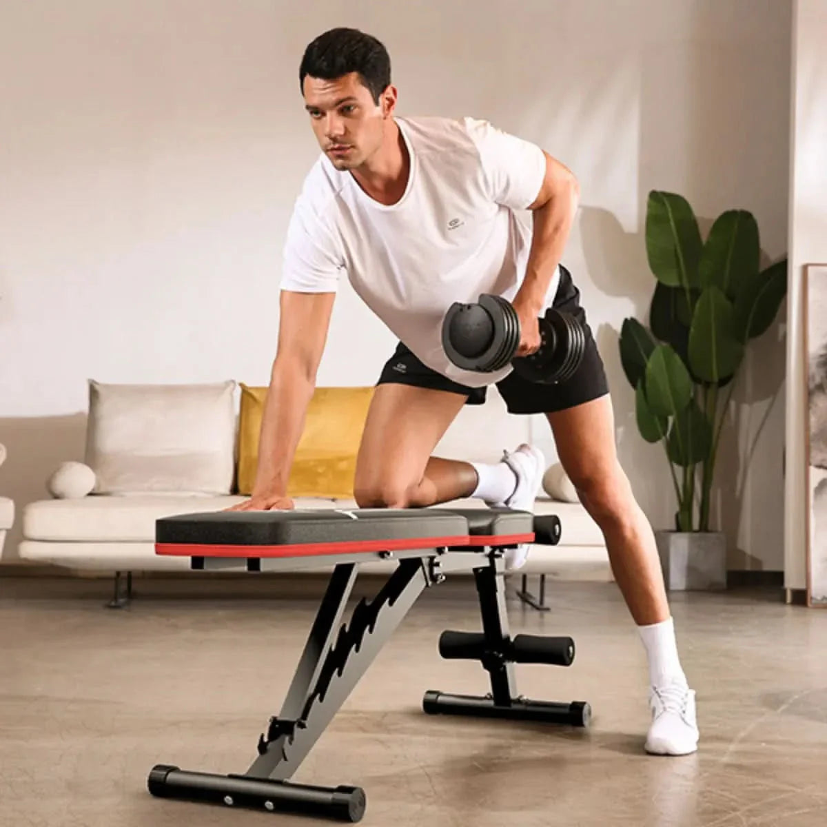 Man exercising with a dumbbell on a adjustable weight bench in a living room.