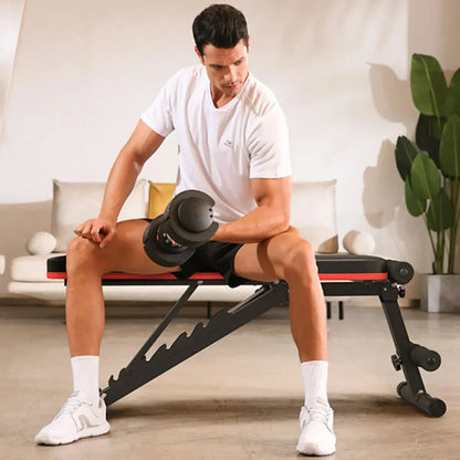 Man sitting on the bench with leg extension and using dumbbell in a home setting